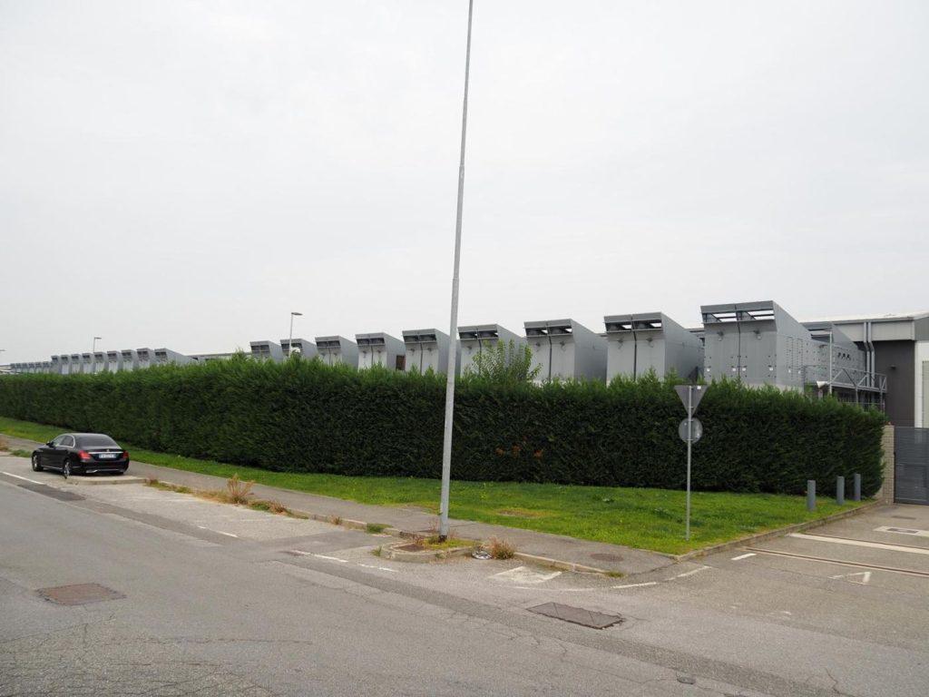 Sensors Help Engineers Spot Data Center Failures Early An engineer walking between rows of servers in a data center checking systems and cabling.
