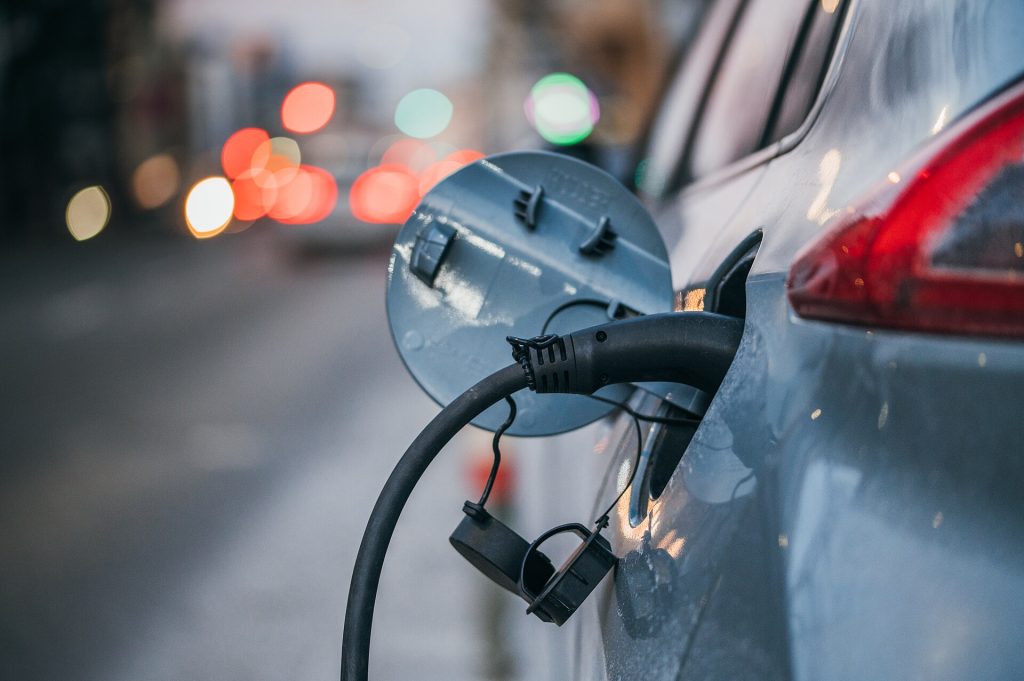 EV Battery Costs Keep Falling. So What Changes? Close-up of an electric car plugged in and charging at the roadside.